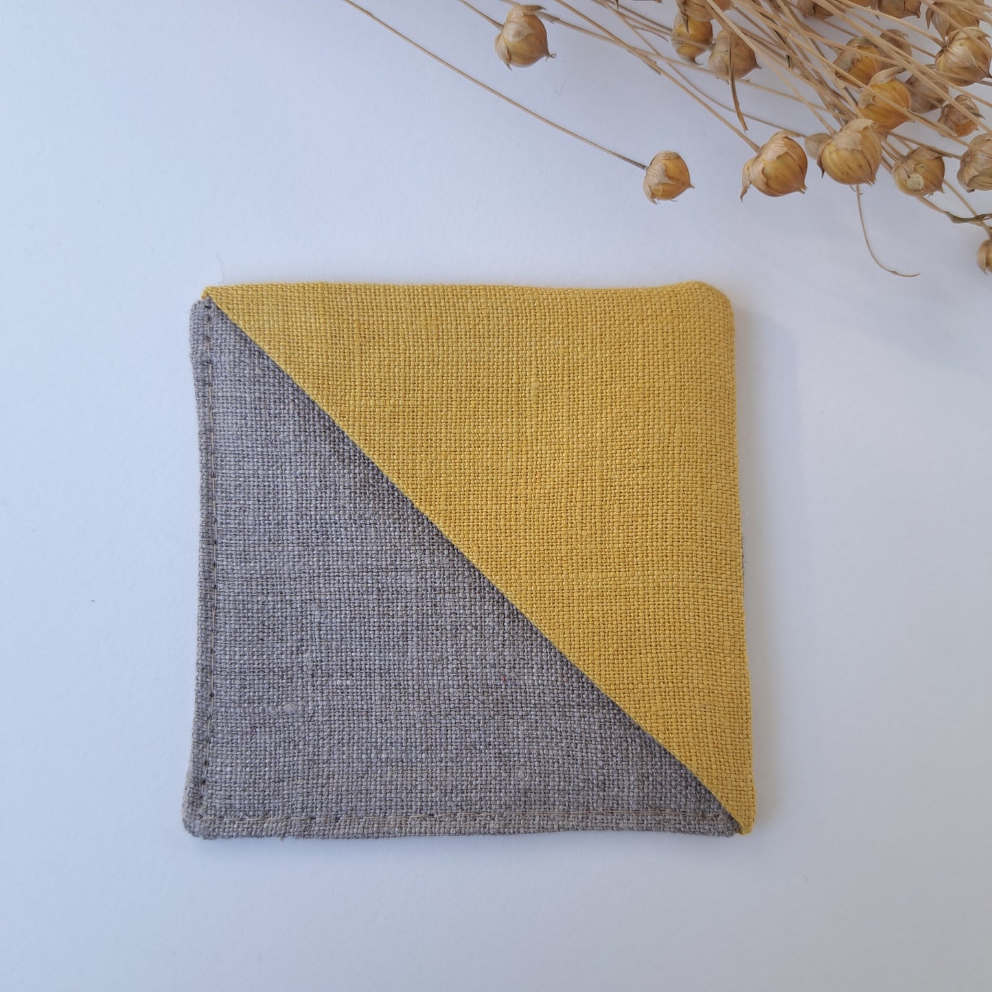 Kulmakirjanmerkki pellavanvärinen tausta ja keltainen kulma.