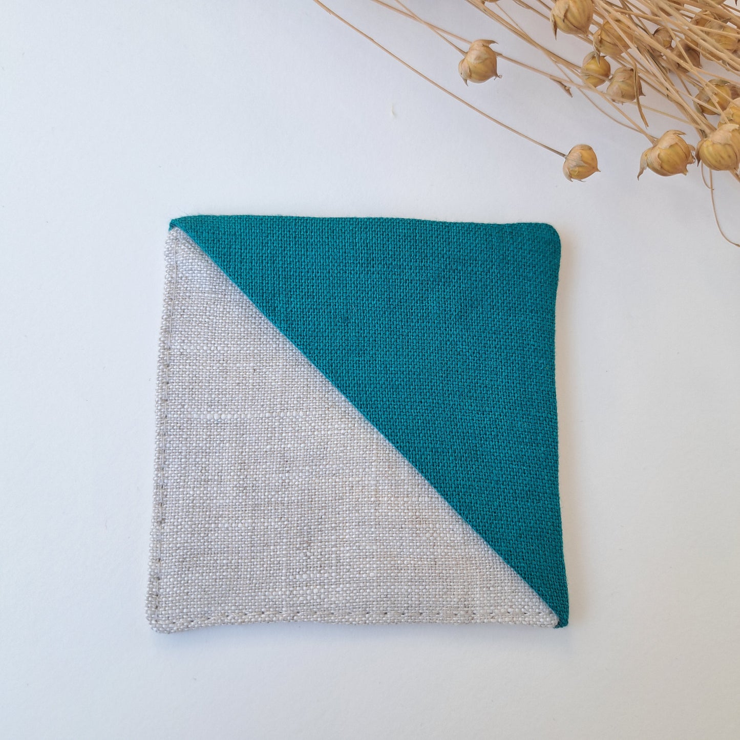 Kulmakirjanmerkki pellavanvärinen tausta ja turkoosi kulma.