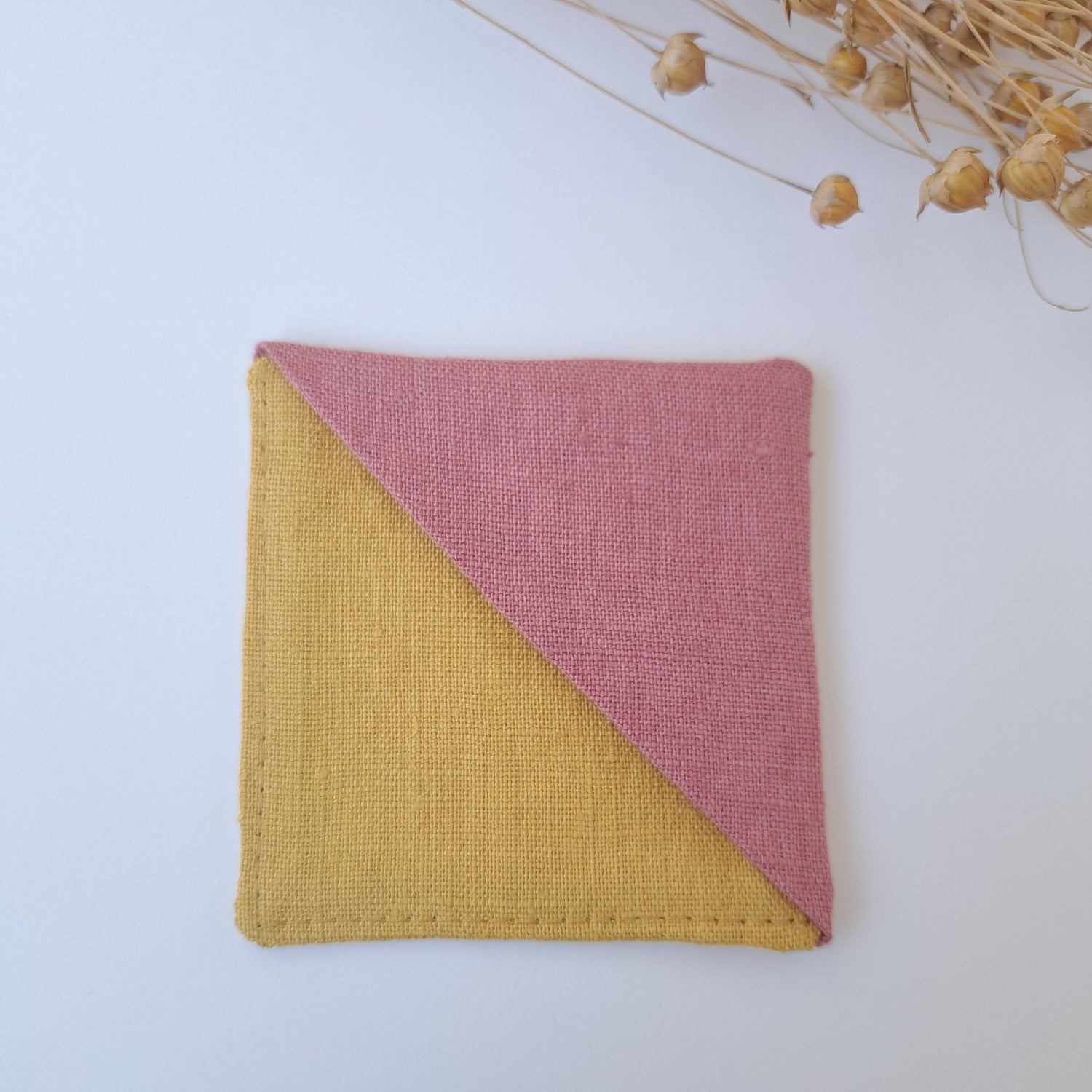 Neliönmuotoinen kirjanmerkki kelta-roosa.