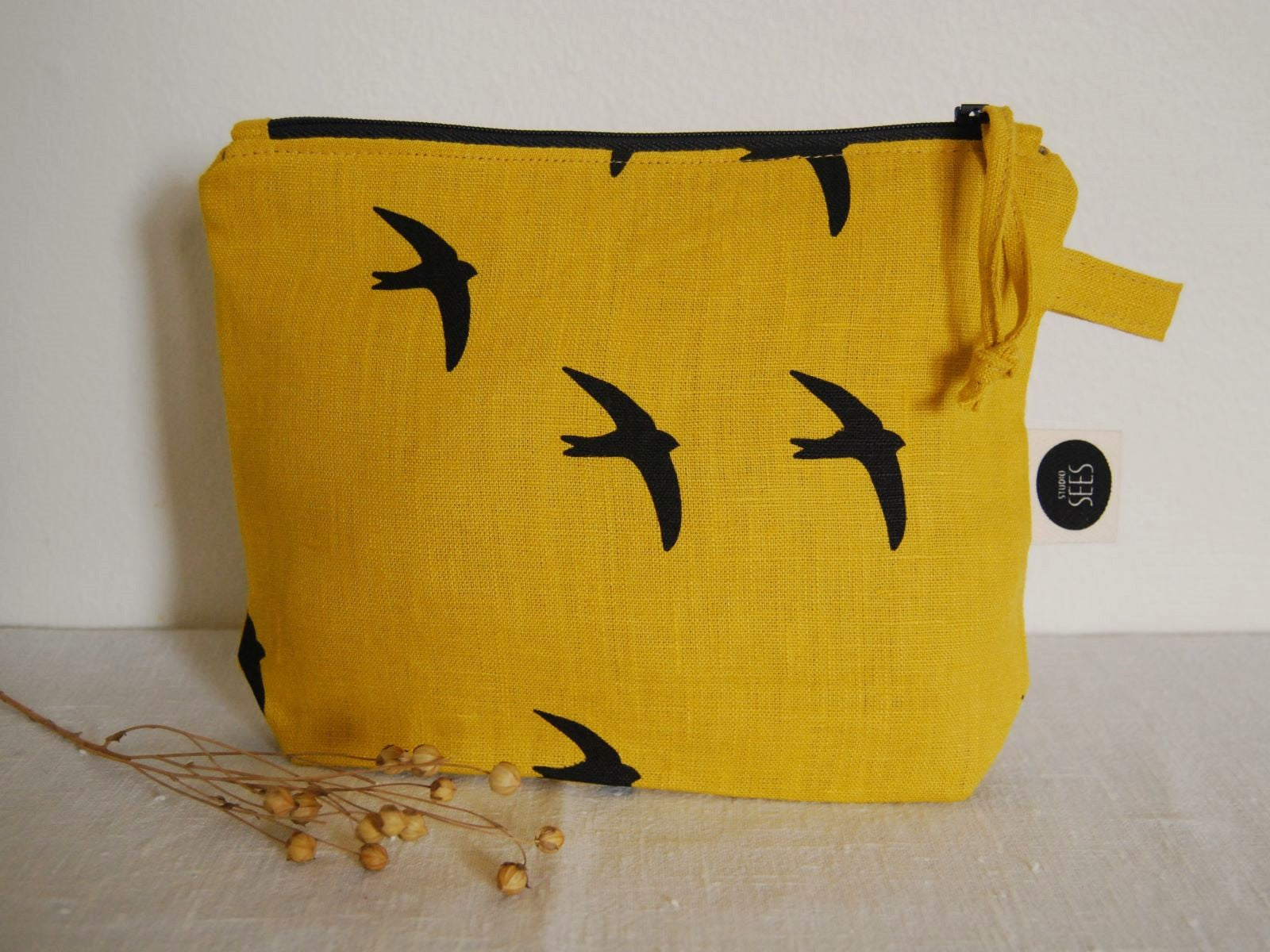 Keltainen pellavainen pussukka, jossa on mustia pääskyjä